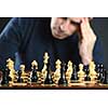 Chessboard with man thinking about chess strategy