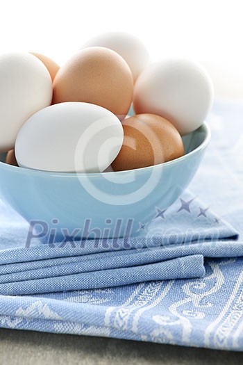 Closeup of white and brown eggs in bowl