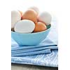 Closeup of white and brown eggs in bowl