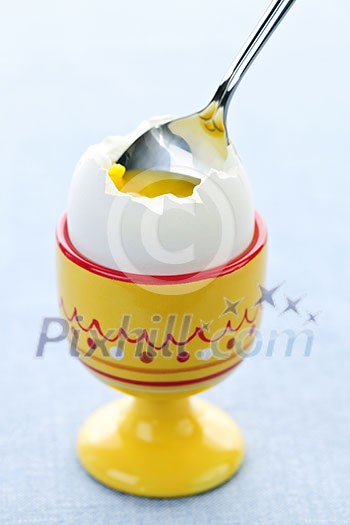 Closeup of soft boiled egg in cup with spoon Closeup of soft boiled egg in cup with spoon