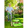 Man with lawn mower in landscaped backyard