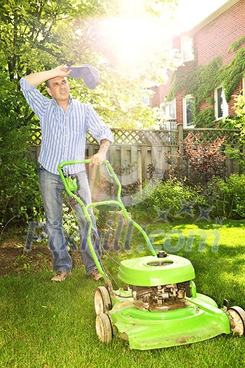 Man taking a break while mowing lawn on hot summer day Man taking a break while mowing lawn on hot summer day