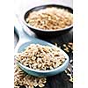 Rolled oats heaped on a spoon and whole oat groats