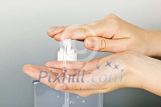 Female hands using hand sanitizer gel pump dispenser
