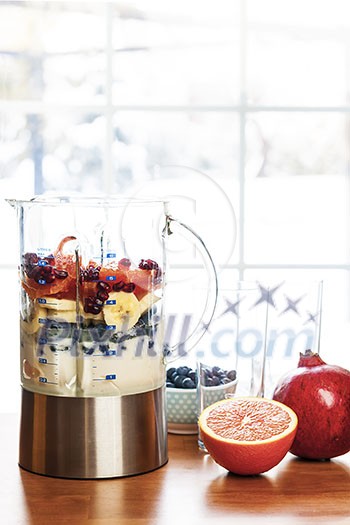 Healthy smoothie ingredients in blender with fresh fruit ready to blend on kitchen table Healthy smoothie ingredients in blender with fresh fruit ready to blend on kitchen table