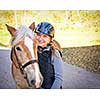 Portrait of teenage girl with horse outdoors on sunny day