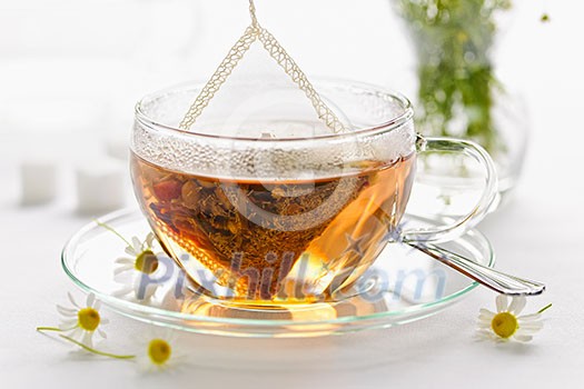 Glass teacup with soothing herbal tea in silk bag Glass teacup with soothing herbal tea in silk bag