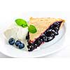 Slice of blueberry pie with vanilla ice cream and berries