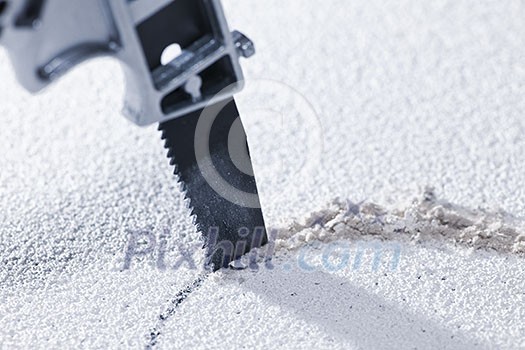 Handsaw cutting circular hole in ceiling tile Handsaw cutting circular hole in ceiling tile