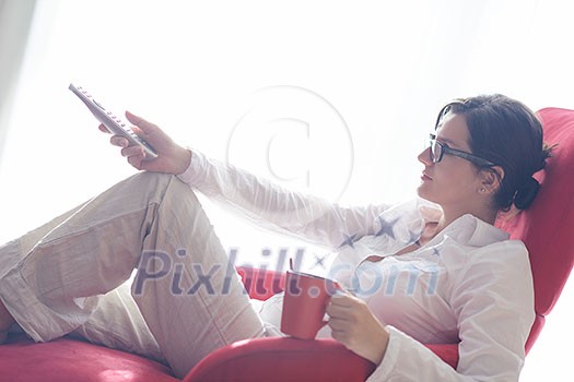 happy young woman relax at home on sofa in bright living room and watching tv happy young woman relax at home on sofa in bright living room and watching tv