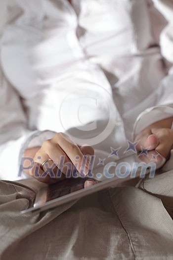 Young woman at home relaxing in her lliving room reading a digital tablet PC surf internet and work Young woman at home relaxing in her lliving room reading a digital tablet PC surf internet and work