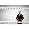 Young businessman in red boxing gloves on cement background