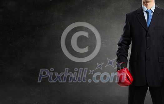 Young businessman in red boxing gloves on cement background Young businessman in red boxing gloves on cement background