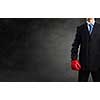 Young businessman in red boxing gloves on cement background