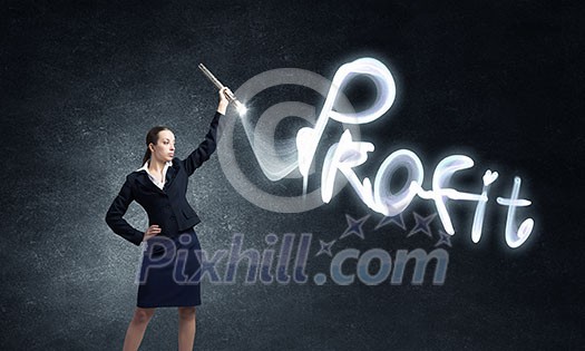 Businesswoman in darkness drawing profit word with flashlight