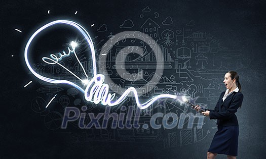 Businesswoman in darkness drawing light bulb with flashlight