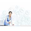 Young businesswoman at desk with laptop and cloud computing concept on background