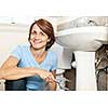 Confident woman repairing sink in bathroom at home