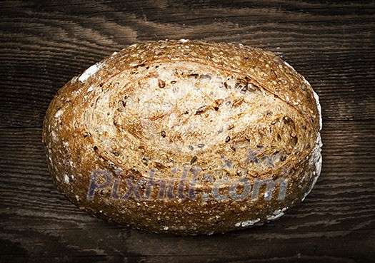 Artisan loaf of freshly baked multigrain bread on wooden background Artisan loaf of freshly baked multigrain bread on wooden background