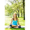 Female fitness instructor in lotus yoga pose outdoor at spring park
