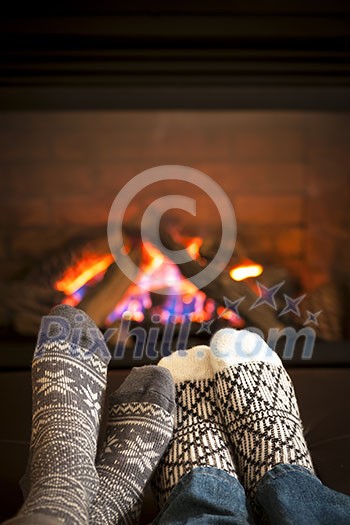 Feet in wool socks warming by cozy fire