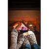 Feet in wool socks warming by cozy fire