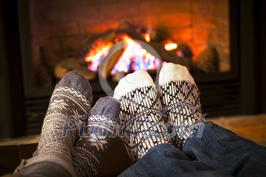 Feet in wool socks warming by cozy fire