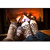 Feet in wool socks warming by cozy fire