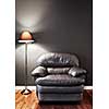 Leather chair and floor lamp against dark wall