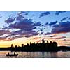 Silhouette of island and canoe on lake at sunset in Algonquin Park, Canada