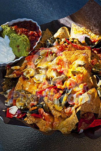 Basket of nachos with cheese jalapeno and toppings Basket of nachos with cheese jalapeno and toppings