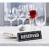 Reserved romantic restaurant table setting with roses plates and cutlery