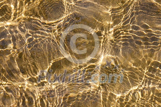 Sunny shallow water ripples over yellow sand bottom Sunny shallow water ripples over yellow sand bottom