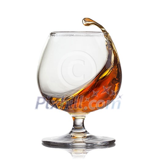 Splash of cognac in glass isolated on white background Splash of cognac in glass isolated on white background
