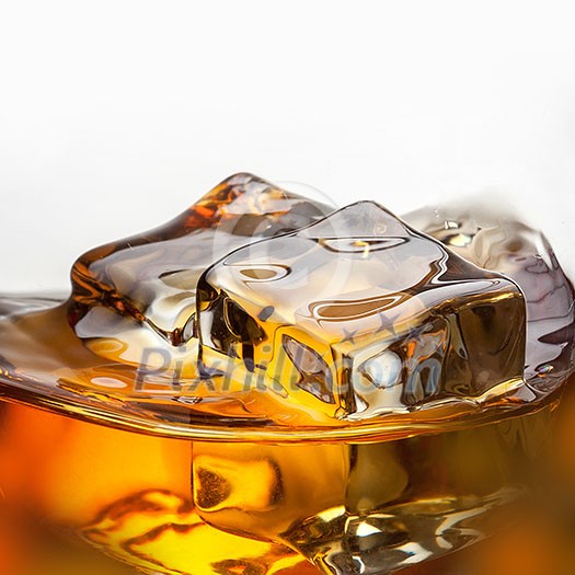 Splash of whiskey with ice in glass isolated on white background Splash of whiskey with ice in glass isolated on white background