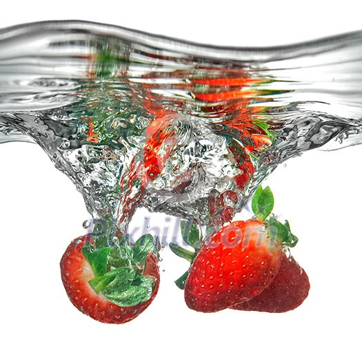 Fresh strawberry dropped into water with splash isolated on white