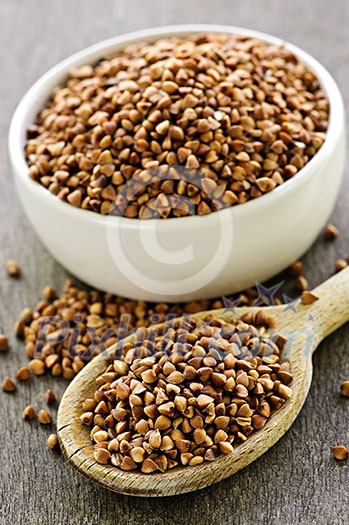 Buckwheat seeds on wooden spoon and in bowl Buckwheat seeds on wooden spoon and in bowl