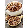 Buckwheat seeds on wooden spoon and in bowl