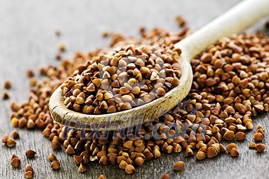 Buckwheat seeds on wooden spoon in closeup