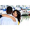 Beautiful young woman hugging boyfriend standing at harbor