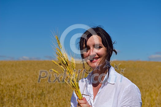 Young woman standing jumping and running on a wheat field with blue sky the background at summer day representing healthy life and agriculture concept Young woman standing jumping and running on a wheat field with blue sky the background at summer day representing healthy life and agriculture concept