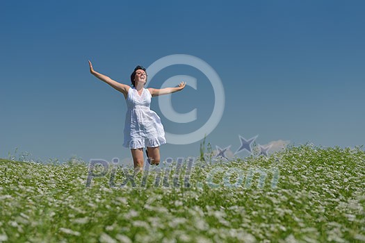 Young happy woman in green field with blue sky in background Young happy woman in green field with blue sky in background