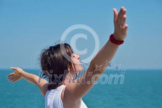 Happy  young woman with spreading arms, blue sky with clouds in background  - copyspace