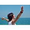 Happy  young woman with spreading arms, blue sky with clouds in background  - copyspace