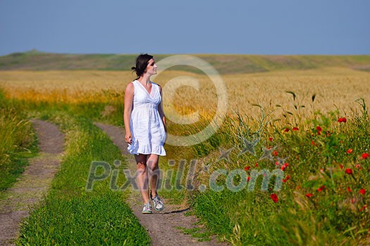 Young happy woman in green field with blue sky in background Young happy woman in green field with blue sky in background