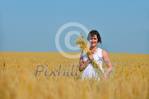 Young woman standing jumping and running on a wheat field with blue sky the background at summer day representing healthy life and agriculture concept Young woman standing jumping and running on a wheat field with blue sky the background at summer day representing healthy life and agriculture concept