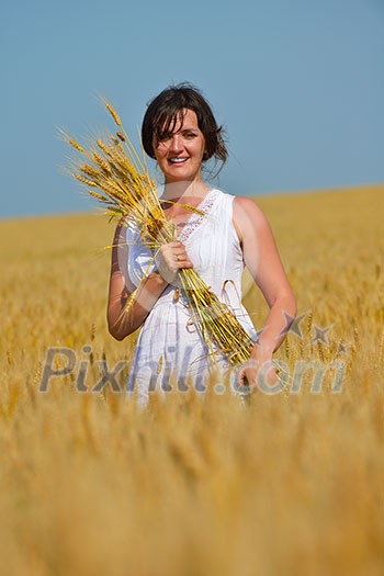 Young woman standing jumping and running on a wheat field with blue sky the background at summer day representing healthy life and agriculture concept Young woman standing jumping and running on a wheat field with blue sky the background at summer day representing healthy life and agriculture concept