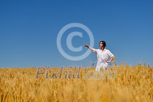 Young woman standing jumping and running on a wheat field with blue sky the background at summer day representing healthy life and agriculture concept Young woman standing jumping and running on a wheat field with blue sky the background at summer day representing healthy life and agriculture concept