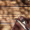 Empty board with fork and knife on wooden table. Top view