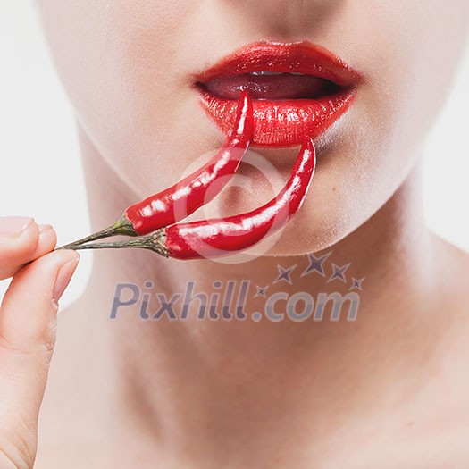 Young woman with chili pepper isolated on white Young woman with chili pepper isolated on white
